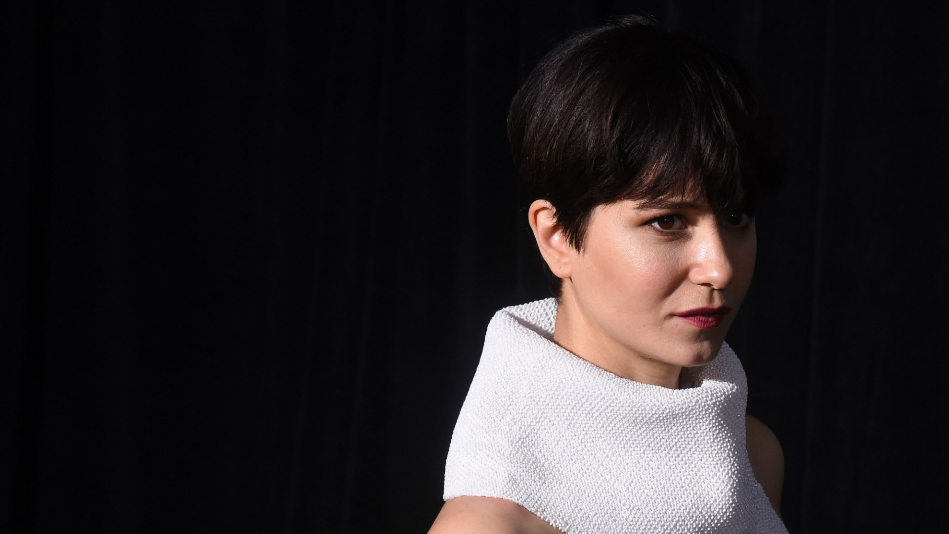 HD desktop wallpaper featuring Katherine Waterston with a thoughtful expression, against a black background.