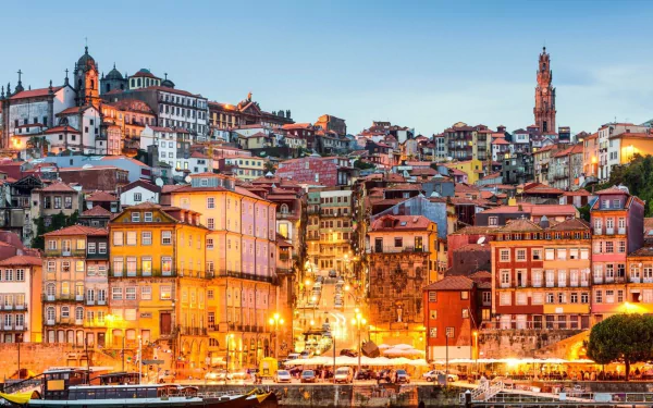HD desktop wallpaper showcasing the colorful, densely packed man-made buildings of Porto illuminated at dusk under a clear sky.