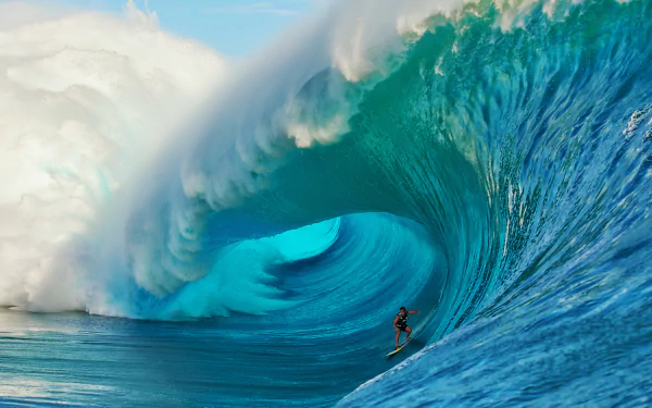 A surfer rides inside a massive, curling ocean wave, captured in stunning HD as a dynamic desktop wallpaper showcasing the power of Earth’s ocean waves and surfing sport.
