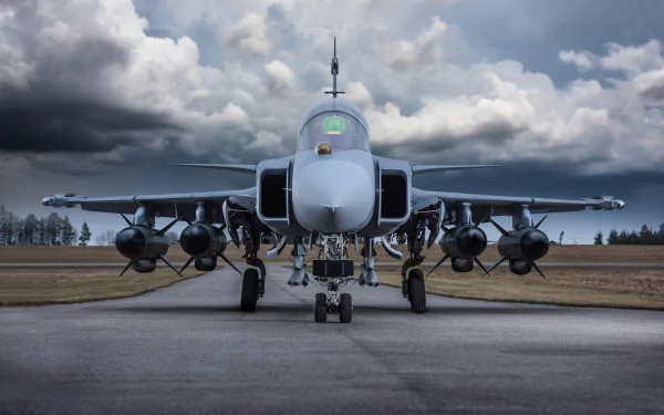 Front view of a Saab JAS 39 Gripen jet fighter warplane on a runway under a cloudy sky, captured in 4K Ultra HD as a military aircraft desktop wallpaper.
