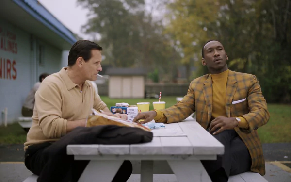 HD desktop wallpaper featuring actors from Green Book, seated at a picnic table in a thoughtful conversation.