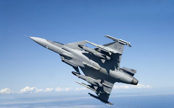 Saab JAS 39 Gripen jet fighter warplane banking over the sea, military aircraft captured as a 4K Ultra HD PC desktop wallpaper.