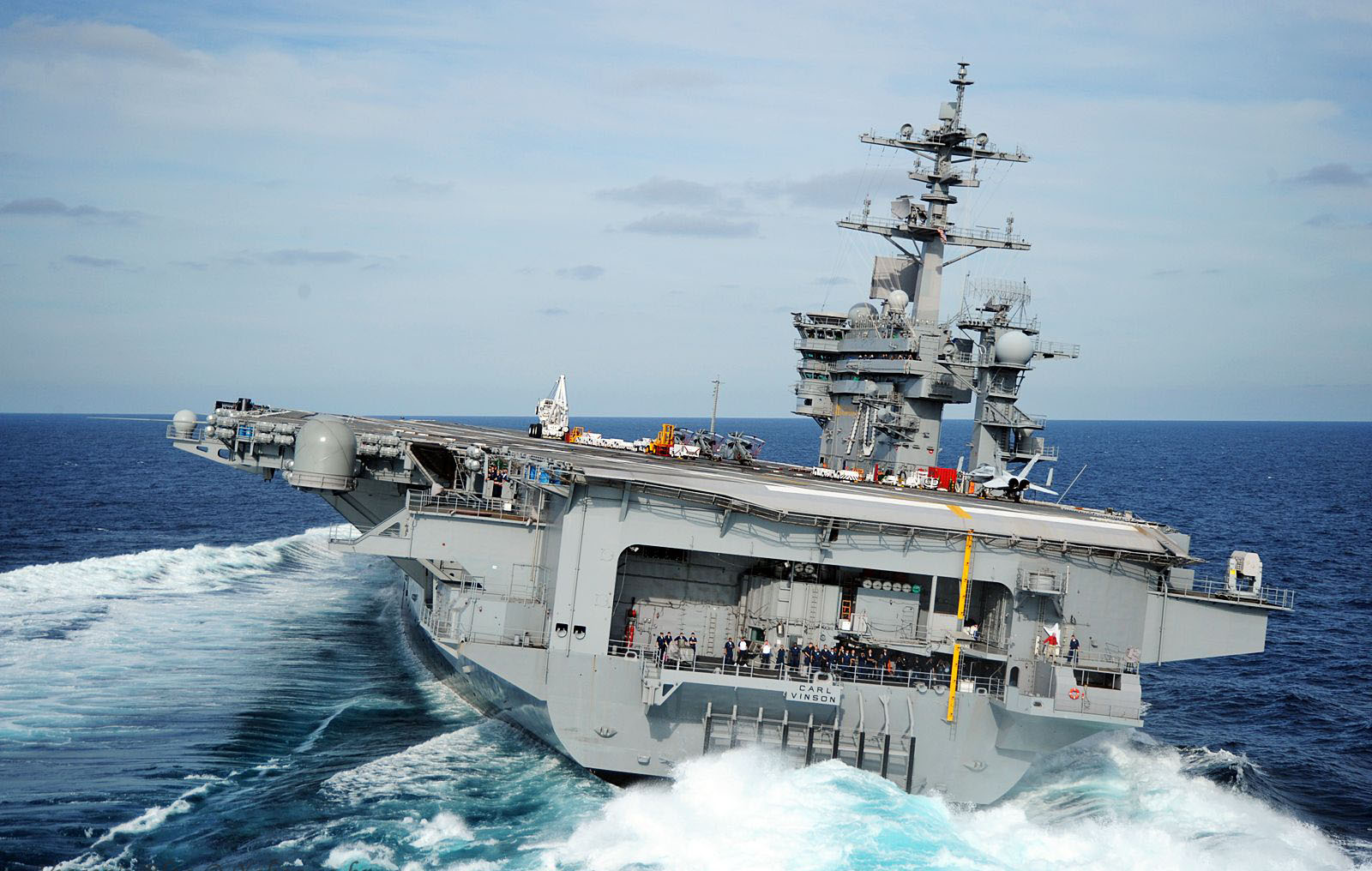 A majestic aircraft carrier, a powerful warship sailing on the calm ocean.