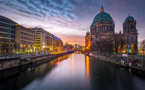 Sunset view of Berlin Cathedral by the river, showcasing religious architecture in Germany with a vibrant sky, captured in HD quality for a desktop wallpaper background.