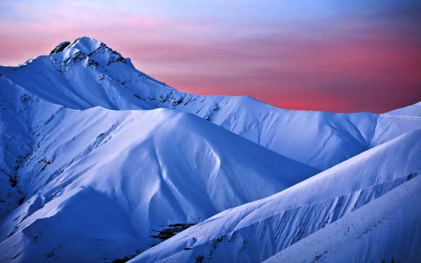 A HD desktop wallpaper and background featuring a serene snow-covered mountain range with a stunning pink and purple sky at dusk in nature.