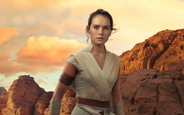 Daisy Ridley as Rey from Star Wars: The Rise of Skywalker stands in a rocky desert landscape at sunset in this 4K Ultra HD PC desktop wallpaper.