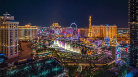 A vibrant 4K Ultra HD night view of downtown Las Vegas, featuring illuminated skyscrapers, fountains, and cityscape landmarks in the USA.