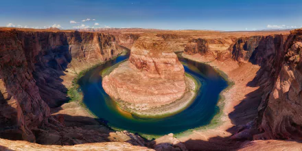 A stunning 8K Ultra HD view of Horseshoe Bend, a Colorado river canyon in the USA, showcasing vibrant natural rock formations and winding blue-green waters under a clear sky.