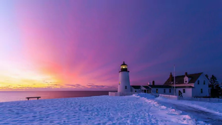 HD wallpaper of a lighthouse at sunset in winter, with vibrant pink skies and snowy surroundings.