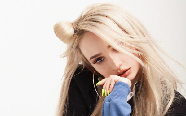 Close-up of a blonde woman with long hair and neon nails, hand to face in a pensive pose against a white backdrop — 2K Quad HD PC desktop wallpaper.