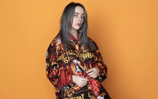 4K Ultra HD desktop wallpaper featuring American singer Billie Eilish against an orange background, blending British and American music influences.