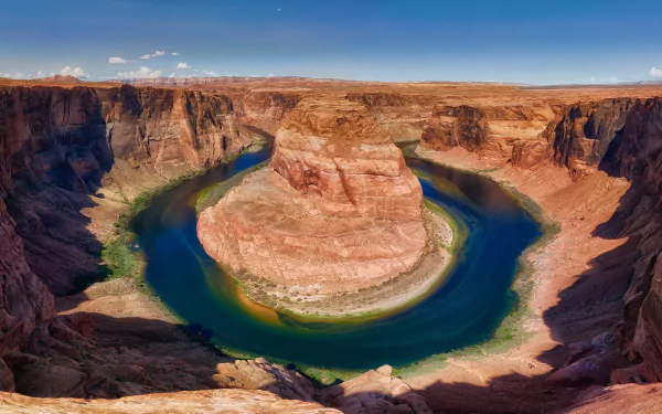 A stunning 8K Ultra HD view of Horseshoe Bend, a Colorado river canyon in the USA, showcasing vibrant natural rock formations and winding blue-green waters under a clear sky.