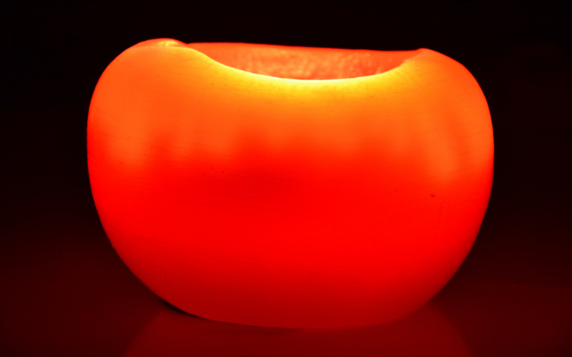 4K Ultra HD photography of a glowing red-orange candle bowl on a black background, minimalist PC desktop wallpaper and background.