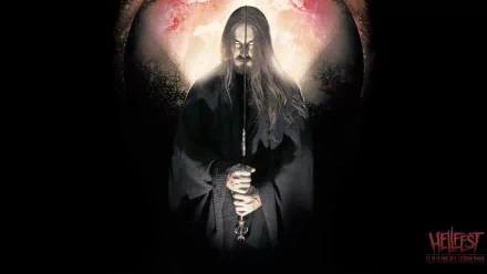 A haunting figure shrouded in darkness holds a candle, set against a vibrant backdrop. An evocative HD wallpaper celebrating the energy of Hellfest and heavy metal music.