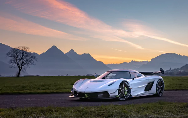 White Koenigsegg Jesko supercar parked on a road with mountains and a colorful sunset sky in the background, captured in 4K Ultra HD for a PC desktop wallpaper.