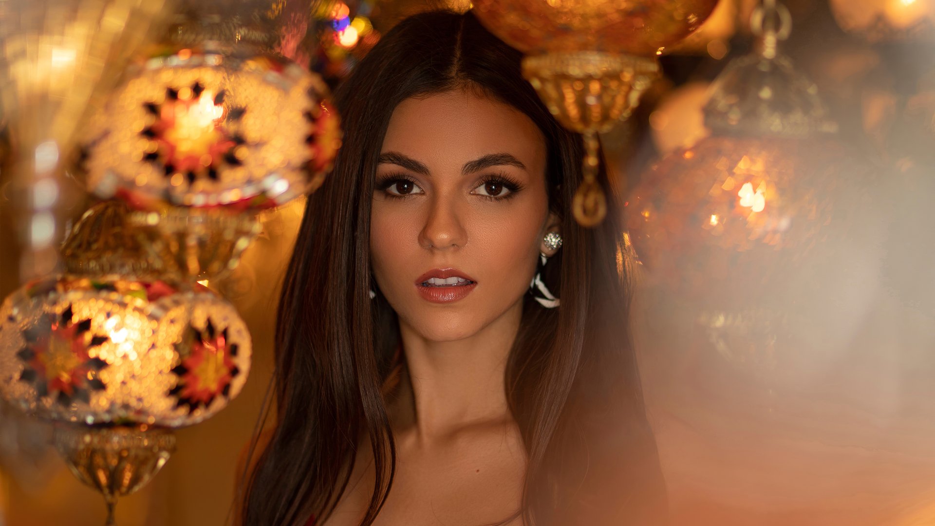4K Ultra HD PC desktop wallpaper: close-up portrait of a brunette woman with brown eyes, warm golden lanterns and soft-focus glow creating an elegant, intimate mood.