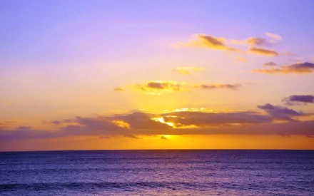 A stunning Hawaiian sunset over the ocean, featuring vibrant colors and clouds, captured in 4K Ultra HD, showcasing the beauty of nature.