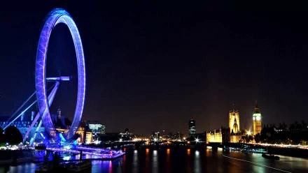 HD desktop wallpaper showcasing London's iconic landmarks: the illuminated London Eye and Big Ben against a night sky over the River Thames.