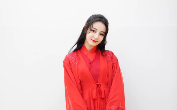 HD desktop wallpaper of Chinese actress and celebrity Dilraba Dilmurat with black hair and red lipstick, dressed in a vibrant red outfit against a plain white background.