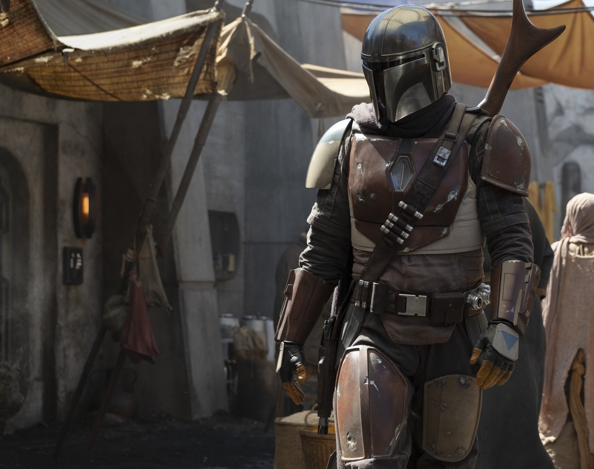 HD PC desktop wallpaper featuring The Mandalorian character from the TV show The Mandalorian, standing in a desert market setting.