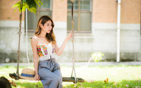 Brunette model on a swing in a sunlit park with shallow depth-of-field — 4K Ultra HD PC desktop wallpaper and background.