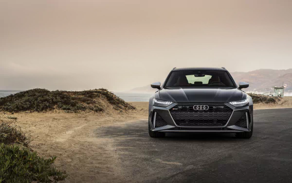 Silver Audi RS6 Avant front view on a coastal desert road under a dramatic sky — 8K Ultra HD PC desktop wallpaper/background