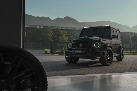 Mercedes‑Benz Brabus 700 vehicle — black G‑Class SUV parked at a garage opening with mountains beyond, 5K Ultra HD PC desktop wallpaper.