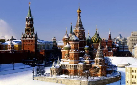 HD desktop wallpaper featuring Saint Basil's Cathedral and the Kremlin towers in snowy Moscow, Russia, highlighting iconic religious and architectural landmarks.