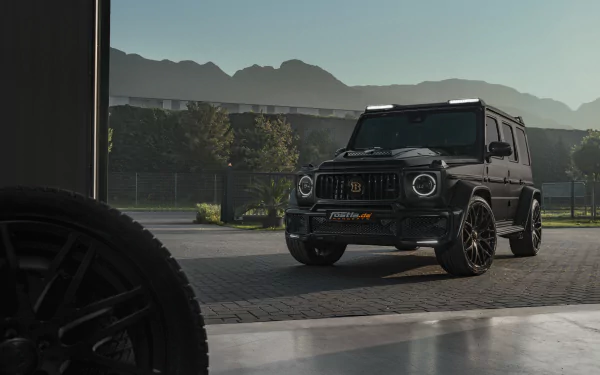 Mercedes‑Benz Brabus 700 vehicle — black G‑Class SUV parked at a garage opening with mountains beyond, 5K Ultra HD PC desktop wallpaper.