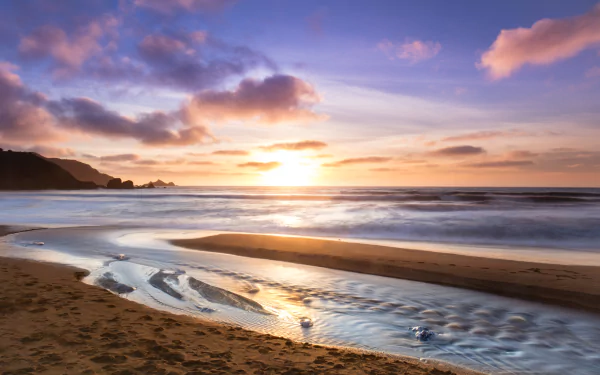 A serene beach at sunrise with gentle waves and a colorful sky, captured in stunning 8K Ultra HD for a vibrant PC desktop wallpaper.