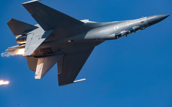Shenyang J-16 jet fighter warplane with afterburners streaking through a clear blue sky — military aircraft, HD PC desktop wallpaper background.