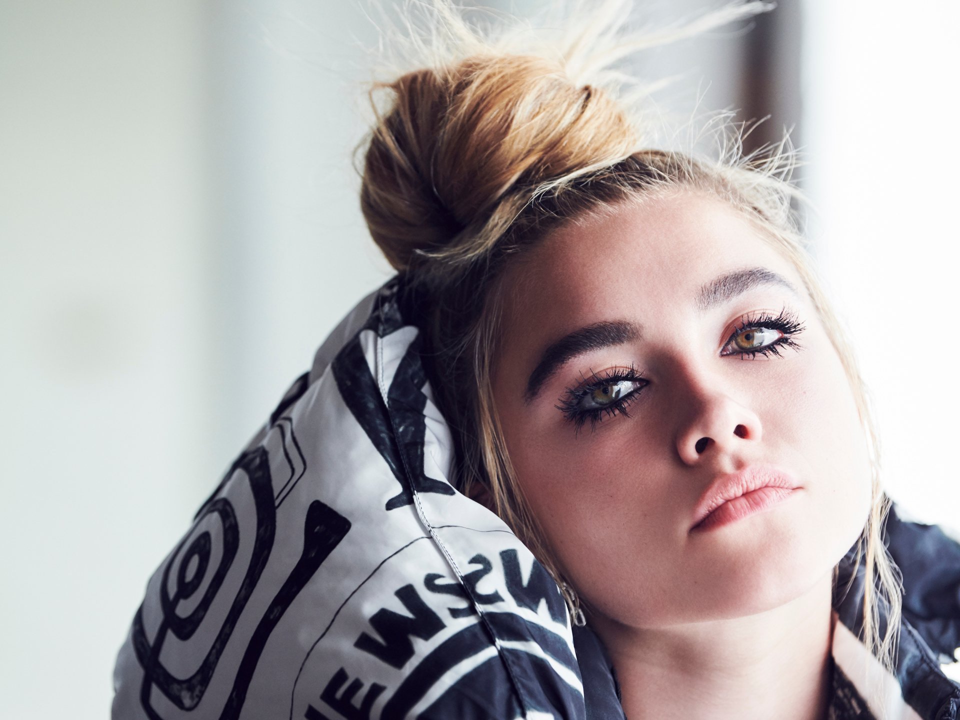 Close-up HD wallpaper of blonde English actress Florence Pugh resting her head against a patterned cushion, showcasing her natural makeup and serene expression.