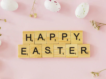 HD PC desktop wallpaper background: wooden Scrabble tiles spell HAPPY EASTER on a pastel pink surface with speckled eggs and dried flowers, a cheerful holiday Easter image.