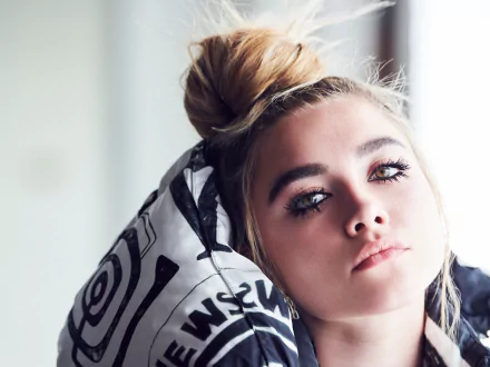 Close-up HD wallpaper of blonde English actress Florence Pugh resting her head against a patterned cushion, showcasing her natural makeup and serene expression.