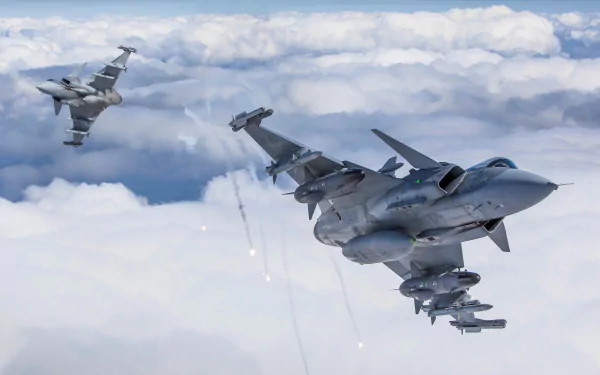 Two Saab JAS 39 Gripen jet fighter warplanes fly through a cloudy sky in this HD military aircraft desktop wallpaper.