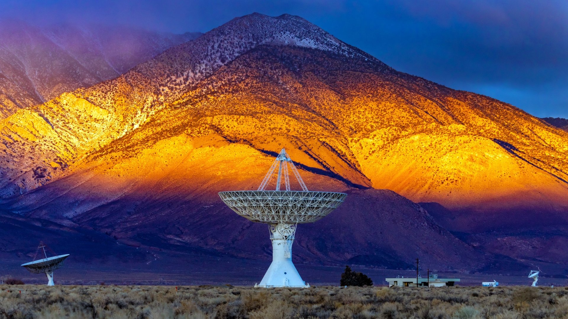 4K Ultra HD desktop wallpaper showing a large man-made telescope dish against a vibrant mountain backdrop illuminated by golden sunlight.