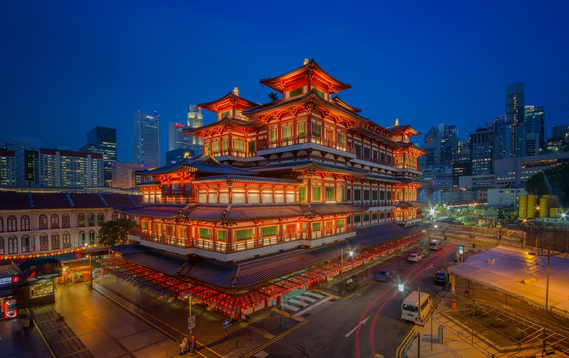 Night view of an illuminated religious temple and museum in Singapore with city skyline — vibrant HD PC desktop wallpaper background.