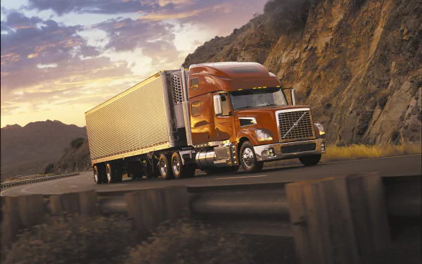 Volvo Truck vehicle hauling a trailer along a mountain highway at sunset — 4K Ultra HD PC desktop wallpaper and background.