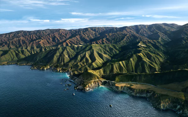 Aerial view of Big Sur coastline and mountains along the ocean, captured in a 4K Ultra HD landscape wallpaper background by Apple Inc.