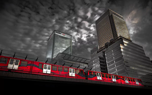 4K Ultra HD wallpaper showing a vibrant red London train passing beneath dramatic clouds with towering city skyscrapers in the background.