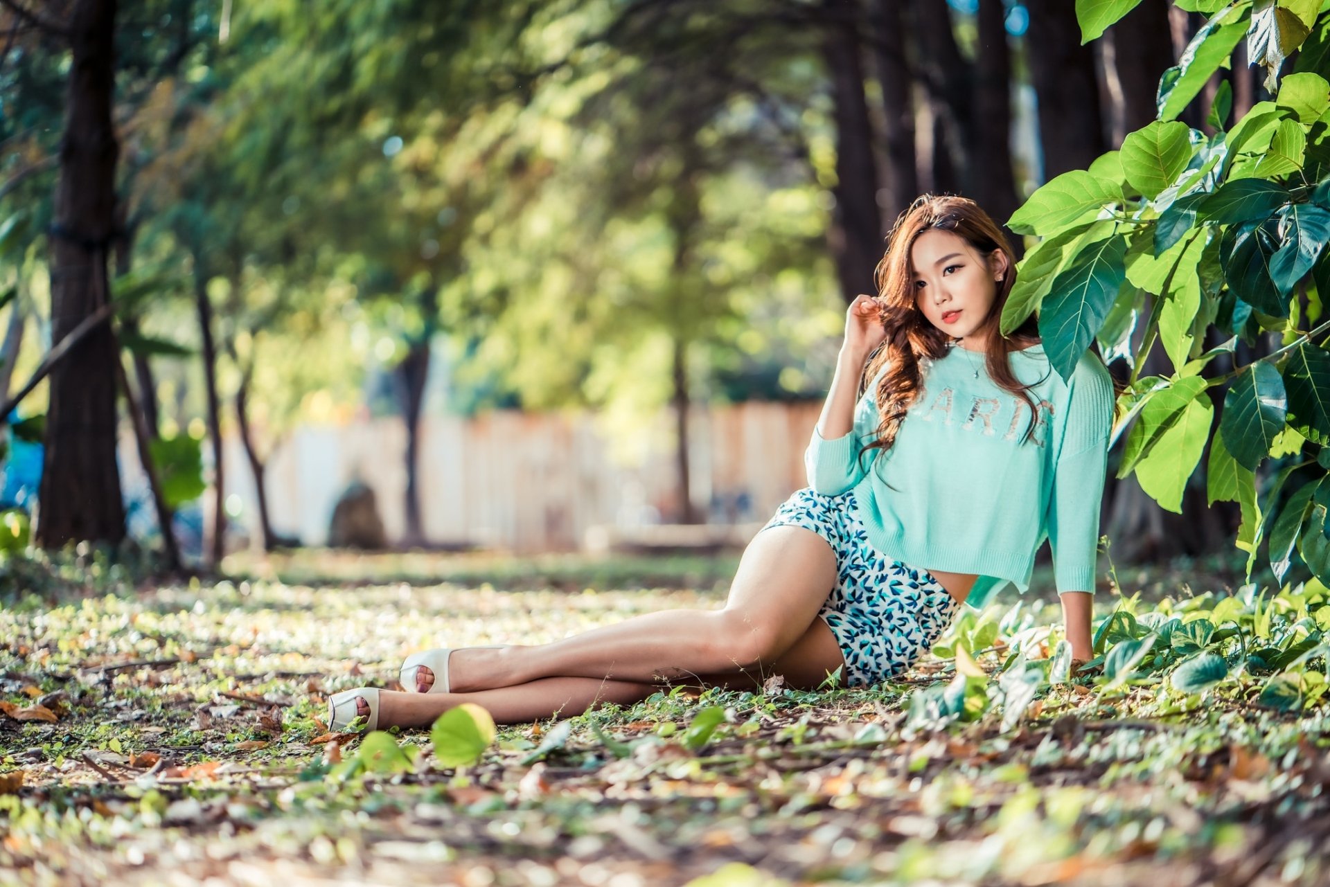 Девушка сидит в листве