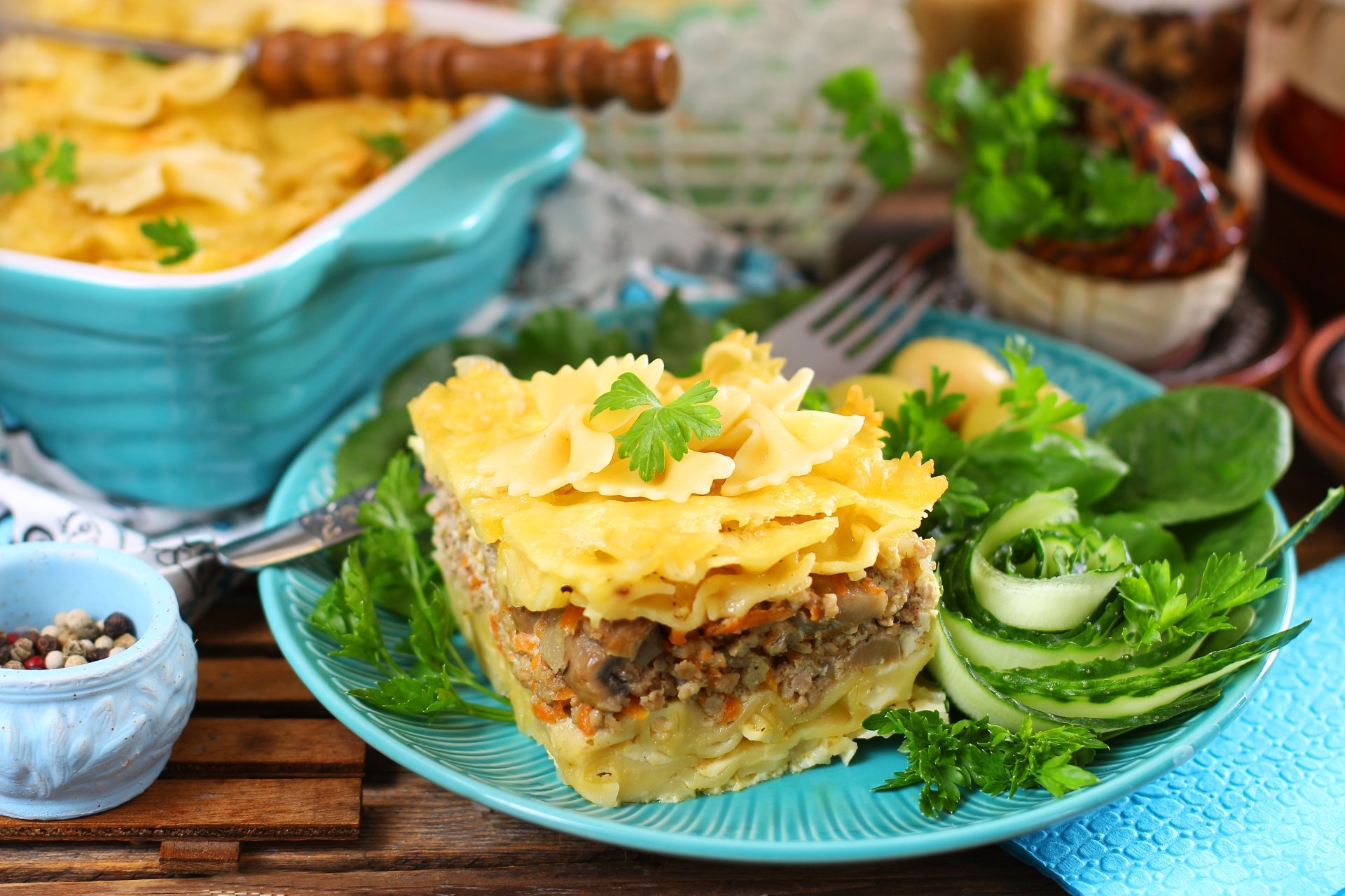 5K Ultra HD PC desktop wallpaper of food: plated pasta stuffing casserole — layered pasta sheets with savory stuffing and herbs, served with fresh greens on a turquoise plate.