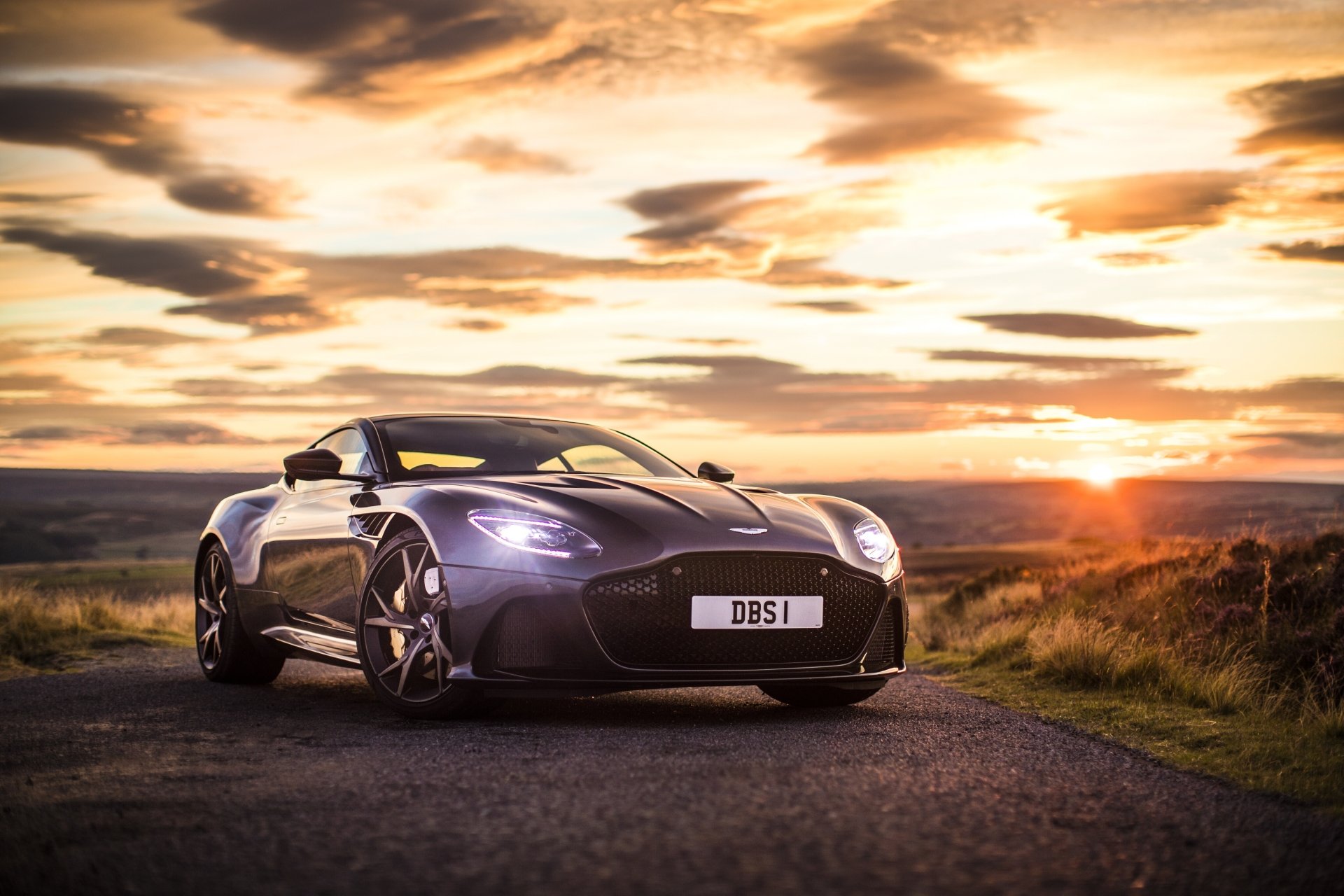 Purple Aston Martin DBS Superleggera parked on a road at sunset, captured in 4K Ultra HD as a PC desktop wallpaper and background.