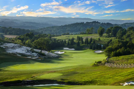 4K Ultra HD view of a man-made golf course pond nestled in a meadow and rolling hills, surrounded by forest in Missouri, USA under a vibrant sky.