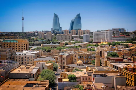 A panoramic view of Baku, Azerbaijan, featuring modern skyscrapers and traditional buildings under a clear blue sky.