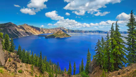 HD PC desktop wallpaper of Crater Lake, Oregon — vivid blue caldera lake with a forested island, rim cliffs and pine trees framing the scenic nature view.