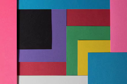 Abstract HD desktop wallpaper featuring a colorful arrangement of textured paper in pink, black, purple, red, green, yellow, and blue.