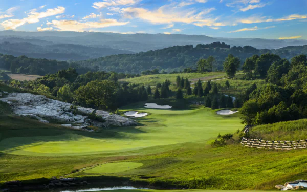 4K Ultra HD view of a man-made golf course pond nestled in a meadow and rolling hills, surrounded by forest in Missouri, USA under a vibrant sky.