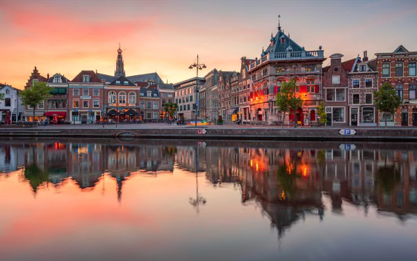 Sunrise over Haarlem, Netherlands, with colorful sky reflecting on calm water, showcasing historic city buildings in stunning 4K Ultra HD detail.