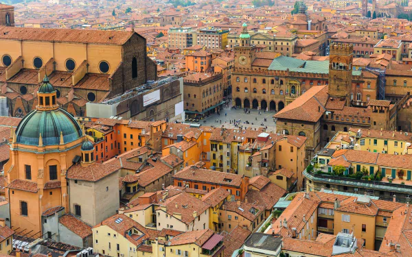 Panoramic view of Bologna, Italy — terracotta roofs, domes and historic buildings clustered around a central square; 2K Quad HD PC desktop wallpaper and background.